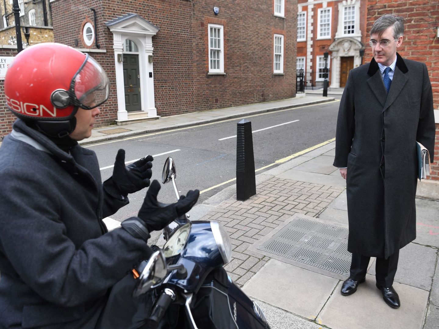 El diputado conservador euroescéptico Jacob Rees-Mogg (d) habla con un ciudadano frente a su residencia en Londres. (EFE)