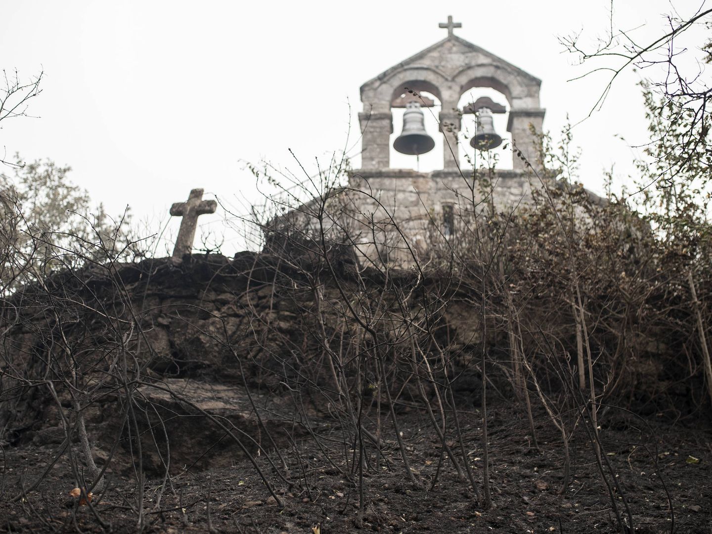 Iglesia y cementerio adyacente con los alrededores calcinados por los incendios. (Brais Lorenzo)