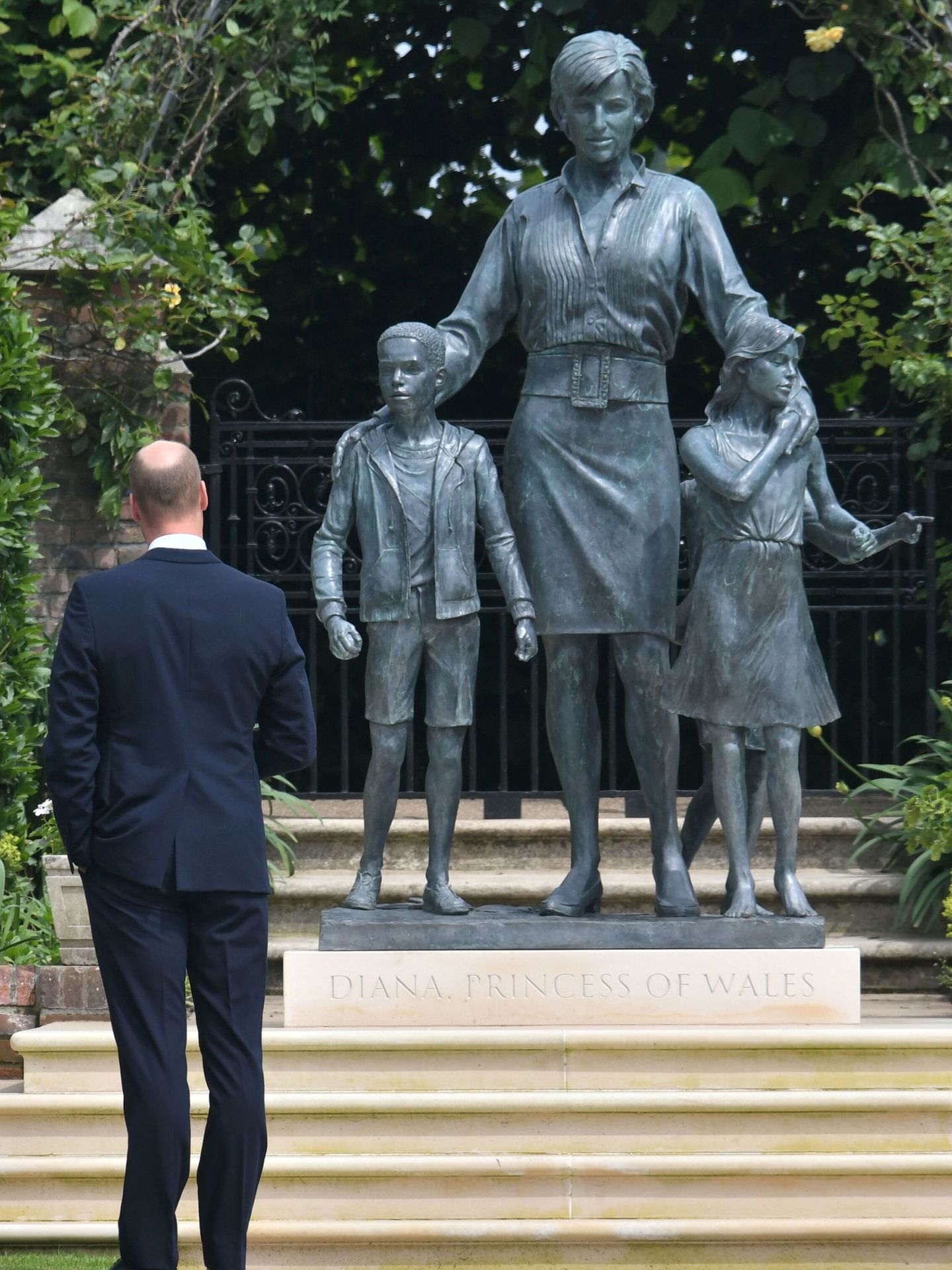 El príncipe William posa con la estatua de su madre. (Reuters)
