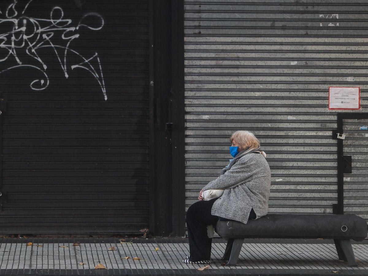 Foto: Mujer frente a un establecimiento cerrado. (EFE)
