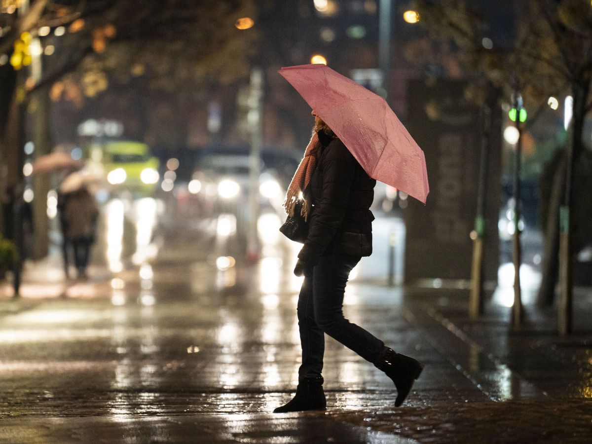 Foto: Un joven se pasea con su paraguas. (EFE/David Borrat)