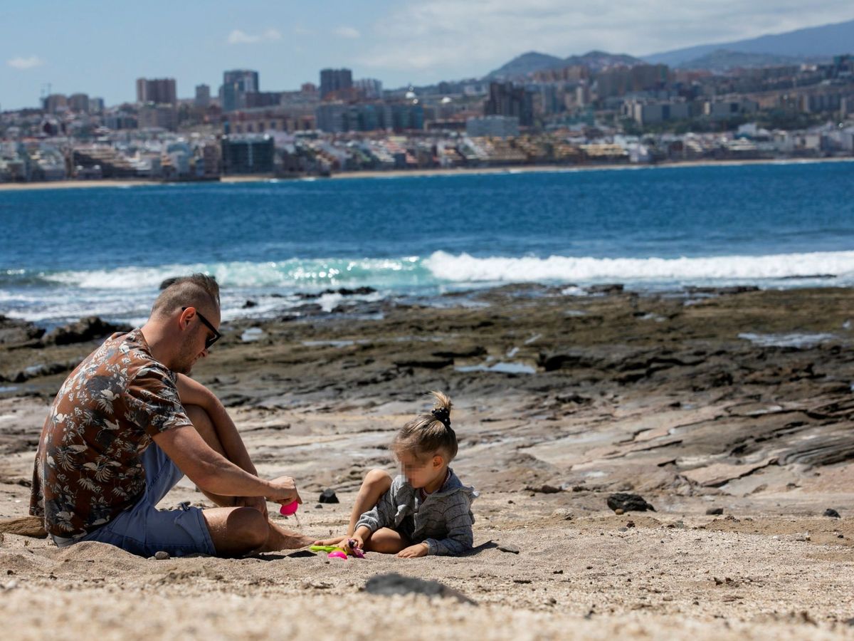 Foto: Un padre y su hija juegan en la playa de El Confital. (EFE)
