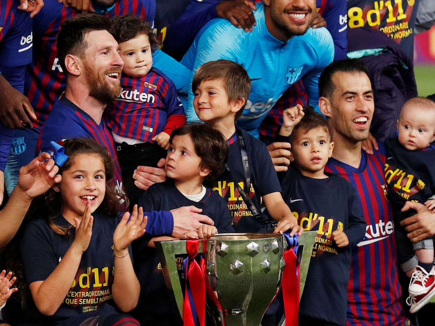 Messi y Busquets celebran el título en el campo. (EFE).