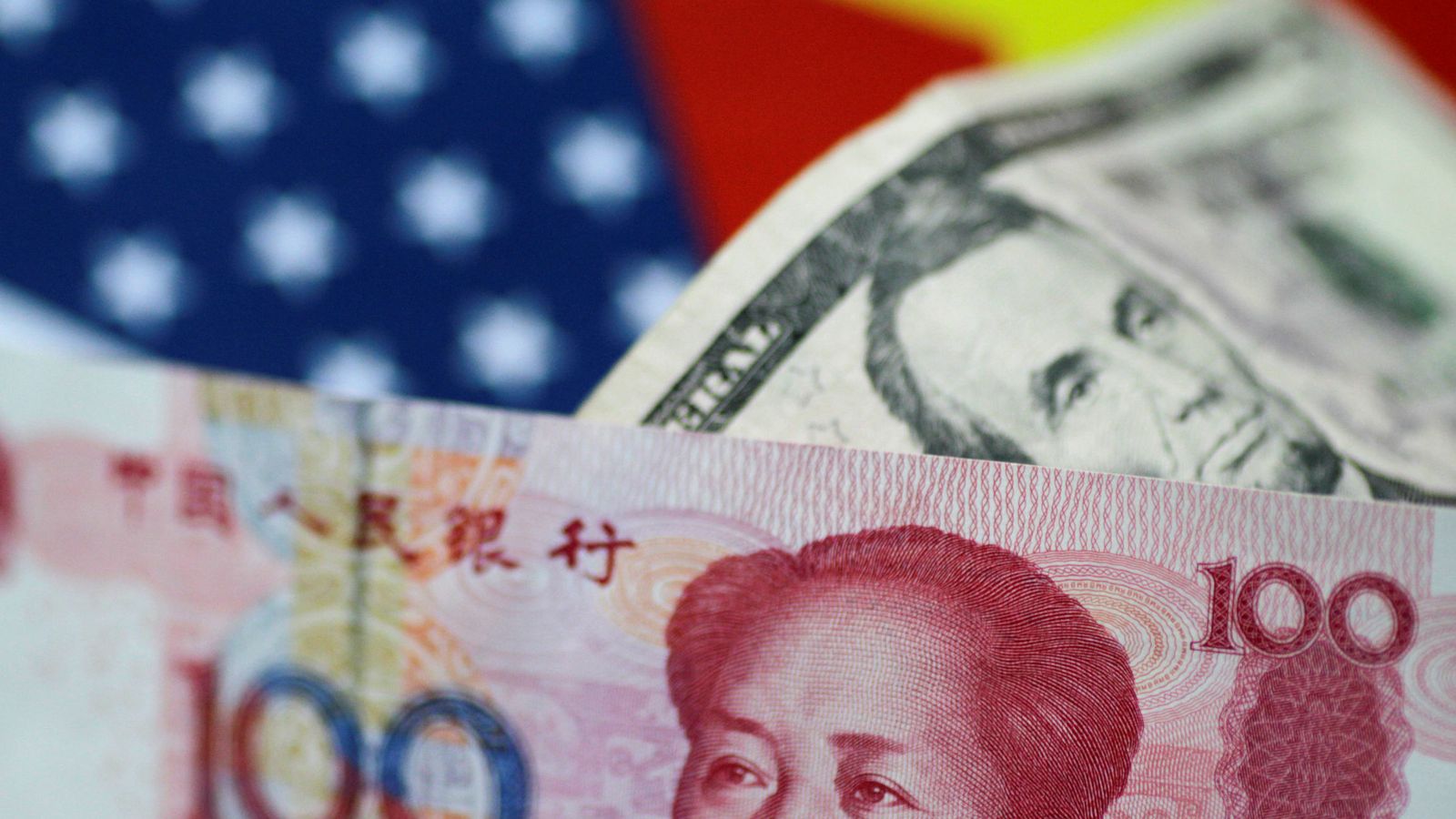 Foto: Ilustración de un dólar y un yuan sobre sus banderas (Reuters)