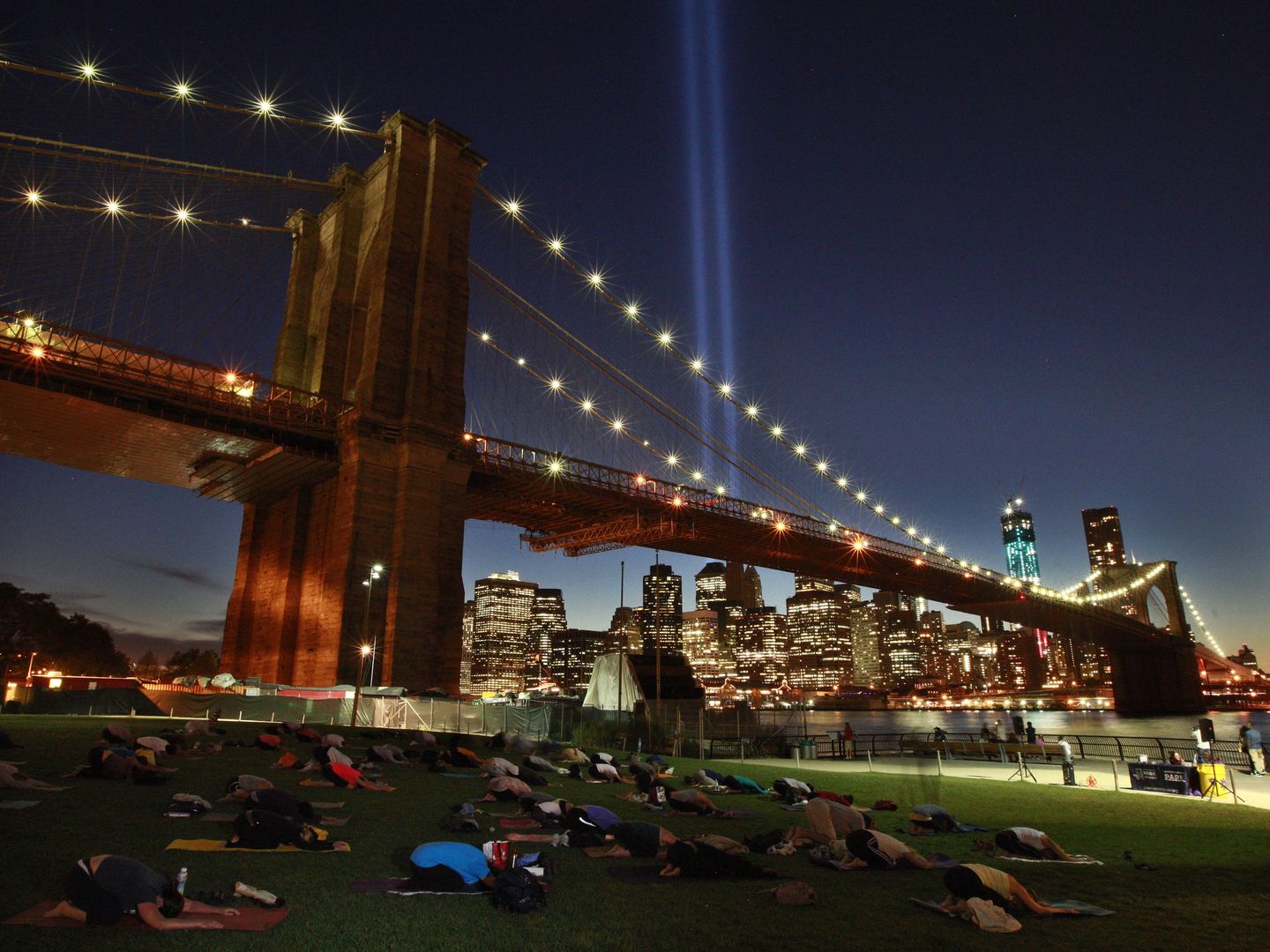 Neoyorquinos participan en una sesión de yoga bajo el Puente de Brooklyn (Reuters).