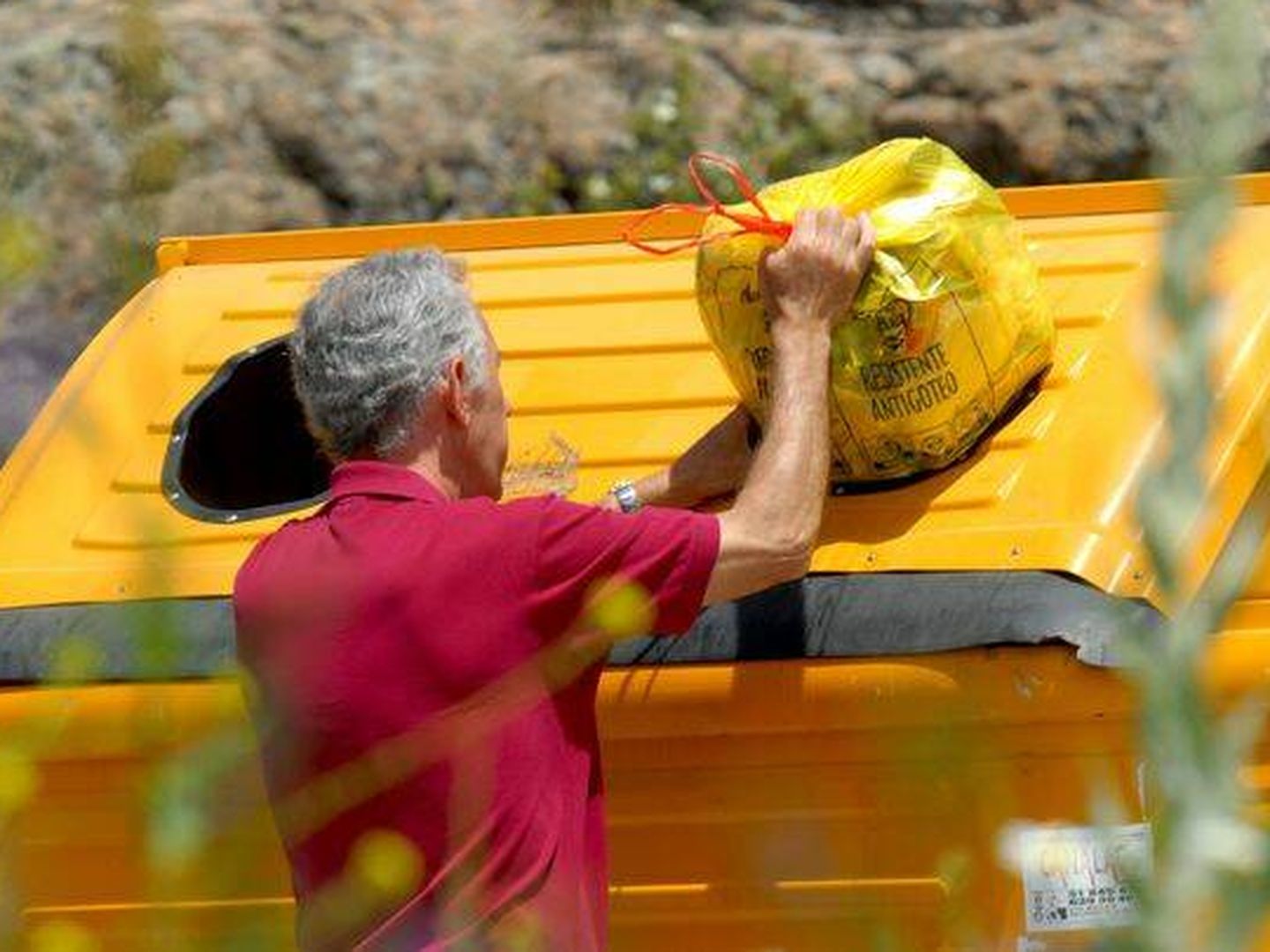 Un ciudadano deposita sus residuos separados en el contenedor amarillo. (Ecoembes)