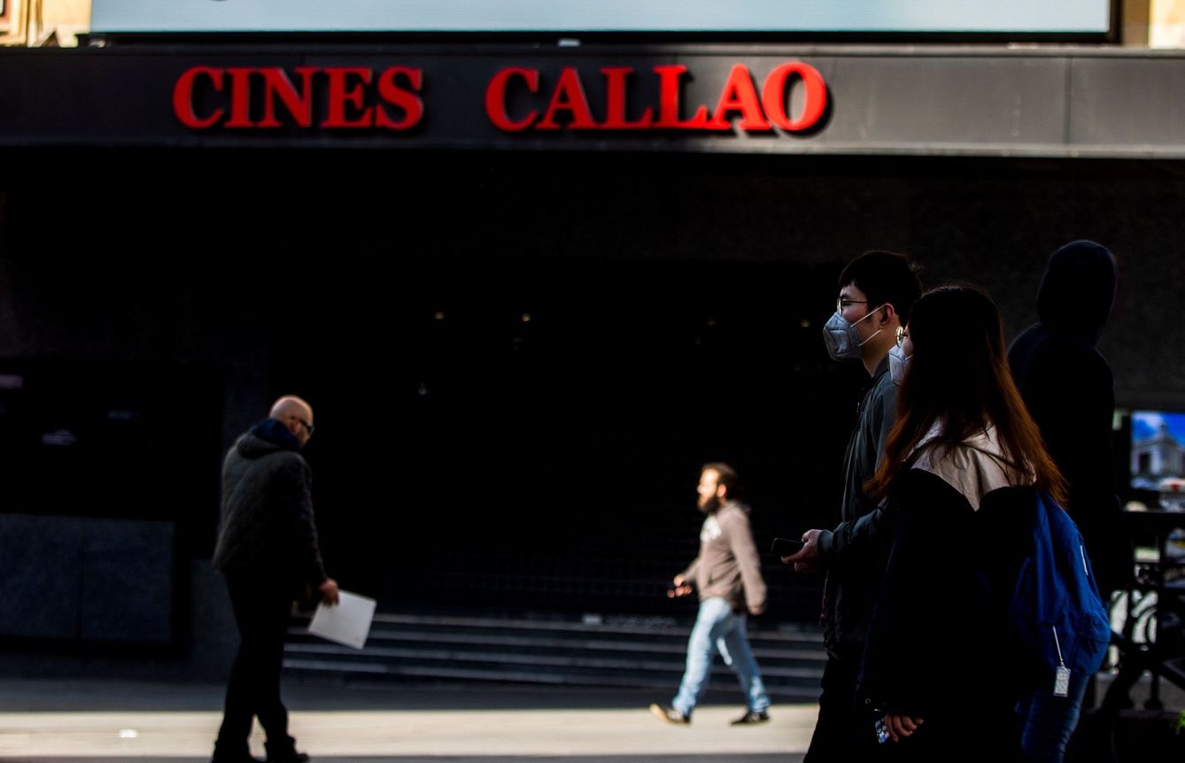 Una pareja camina junto a los cines Callao, en Madrid, cerrados desde poco antes de la declaración del estado de alarma. (EFE)