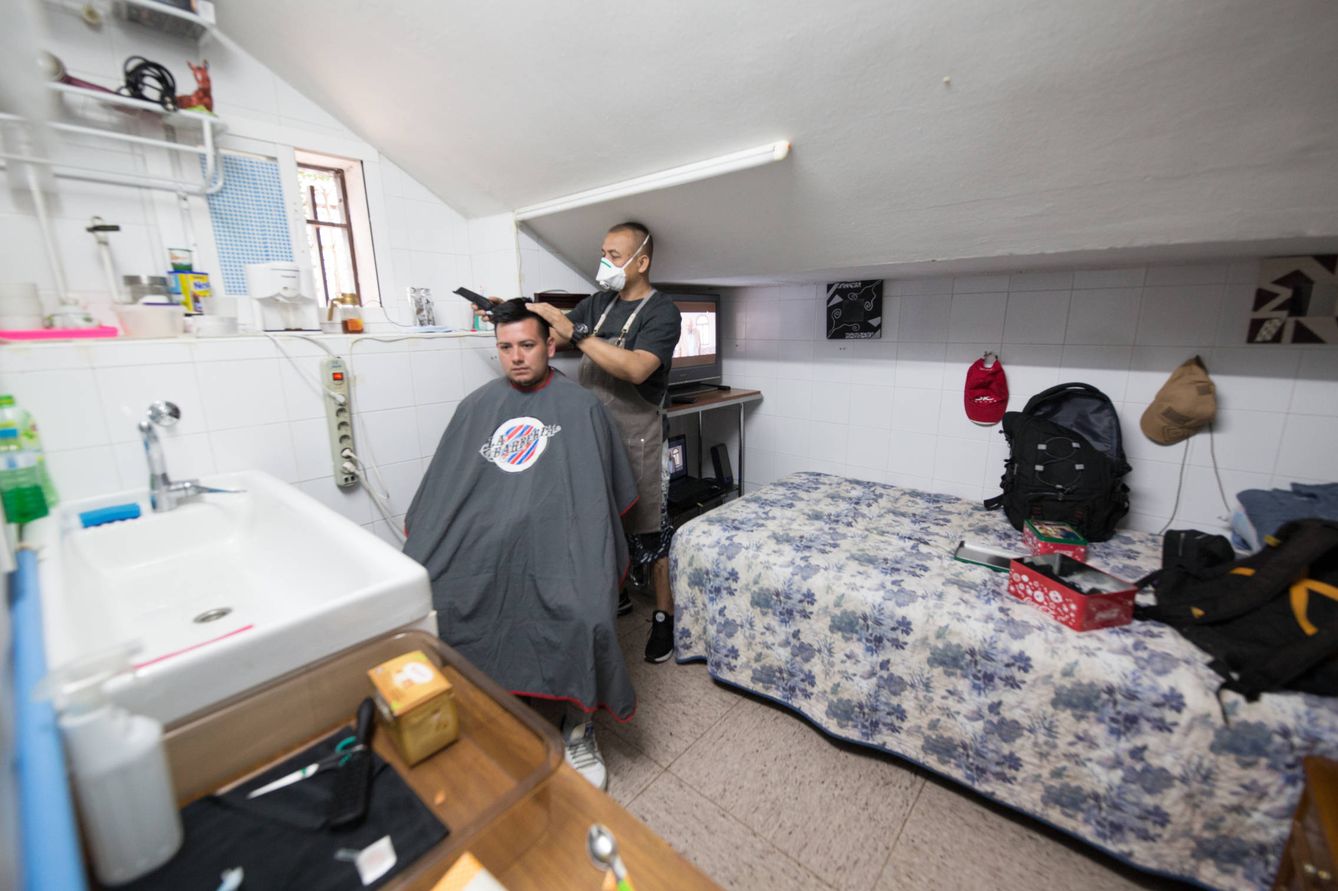 Walter Cardona corta el pelo a un compañero en su habitación temporal. (D.B.)