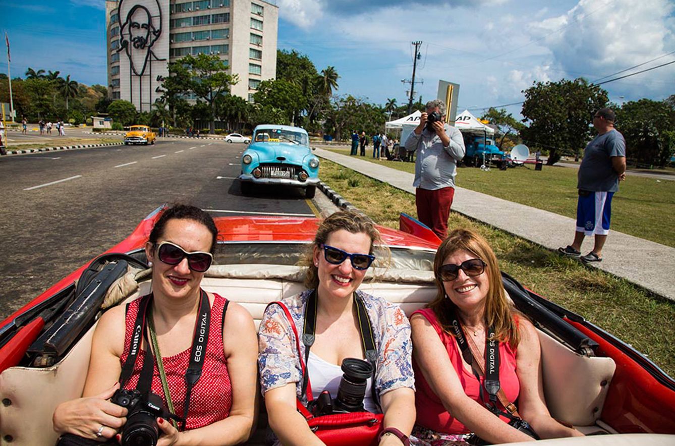 Tres mujeres recorren La Habana vieja en uno de los automóviles de la época previa al bloqueo.