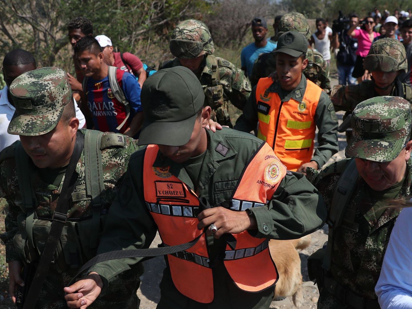 Miembros del Ejército de Colombia acompañan a dos agentes de la Guardia Nacional Bolivariana (GNB) que desertaron este lunes en la frontera. (EFE)