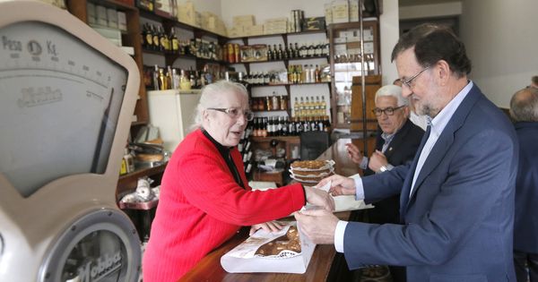 Foto: El presidente del Gobierno, Mariano Rajoy, recibe una tarta que le regala la dueña de una tienda en agradecimiento por su visita en 2016. (EFE)