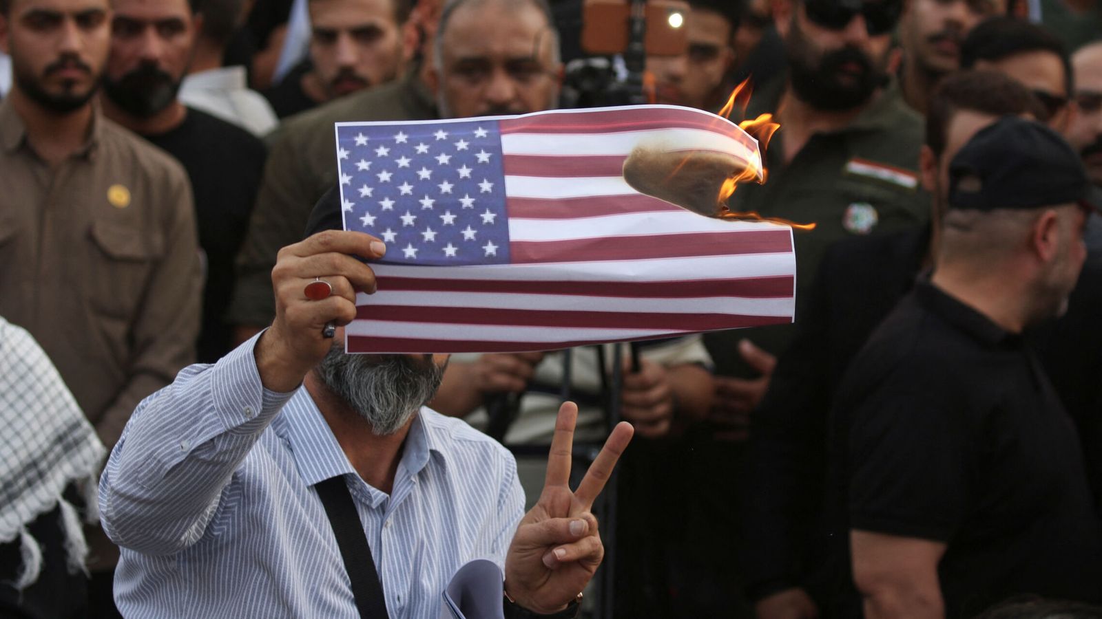 Un manifestante quema una bandera estadounidense. (Reuters)