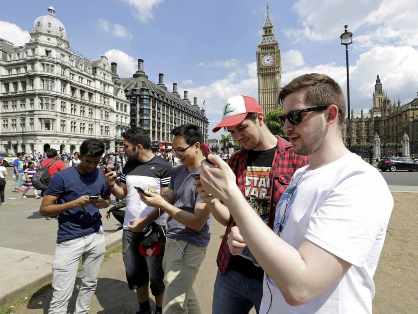 Varios chicos utilizan su móvil frente al Big Ben de Londres (Reuters)