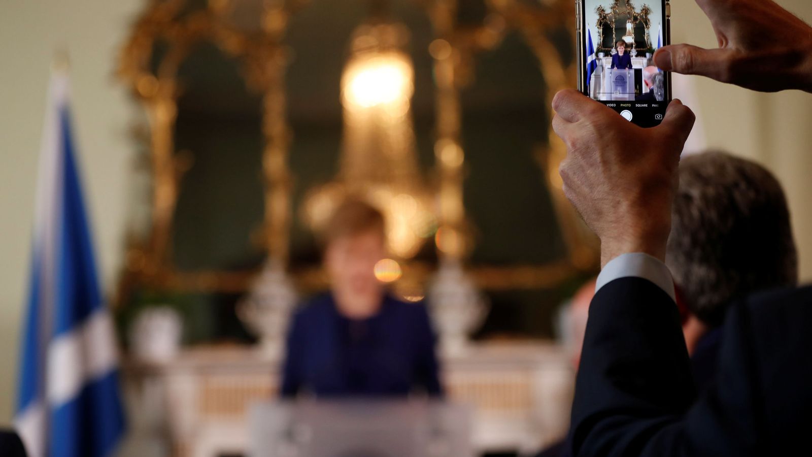 Foto: Un hombre filma a la ministra principal de Escocia, Nicola Sturgeon, mientras habla a la prensa en Edimburgo tras las elecciones, el 9 de junio de 2017. (Reuters)