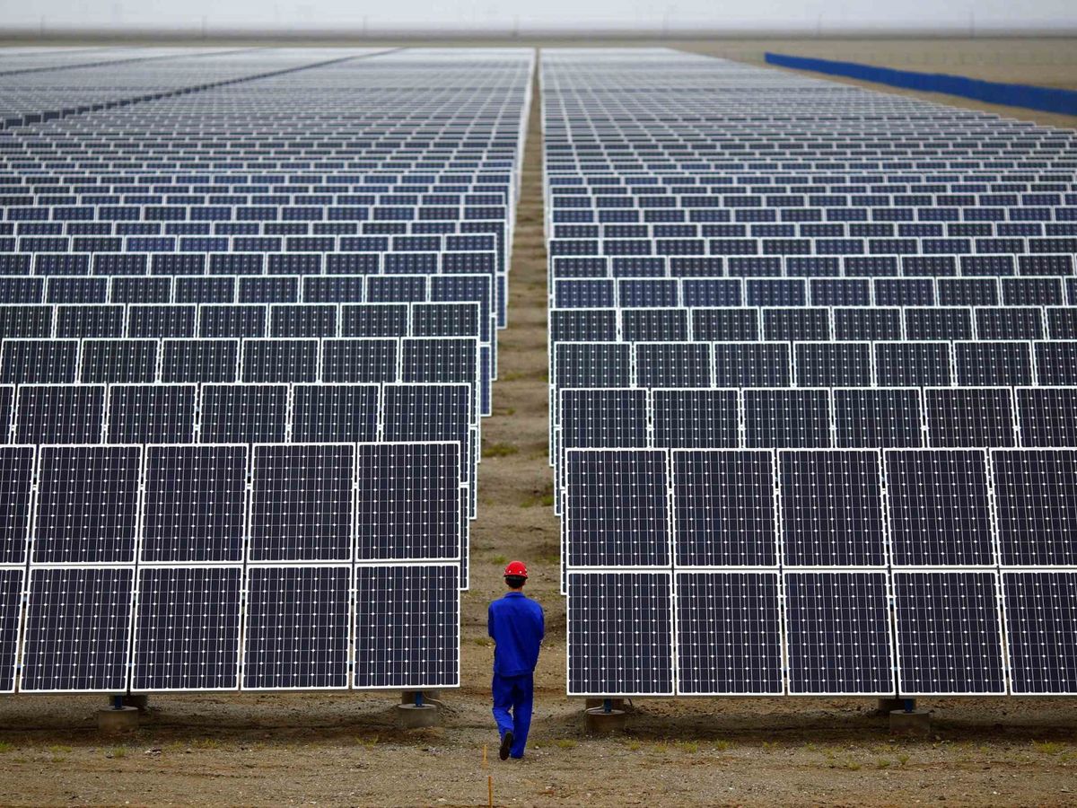 Foto: Un trabajador inspecciona una serie de paneles solares en Dunhuang (China). (Reuters/Carlos Barría)