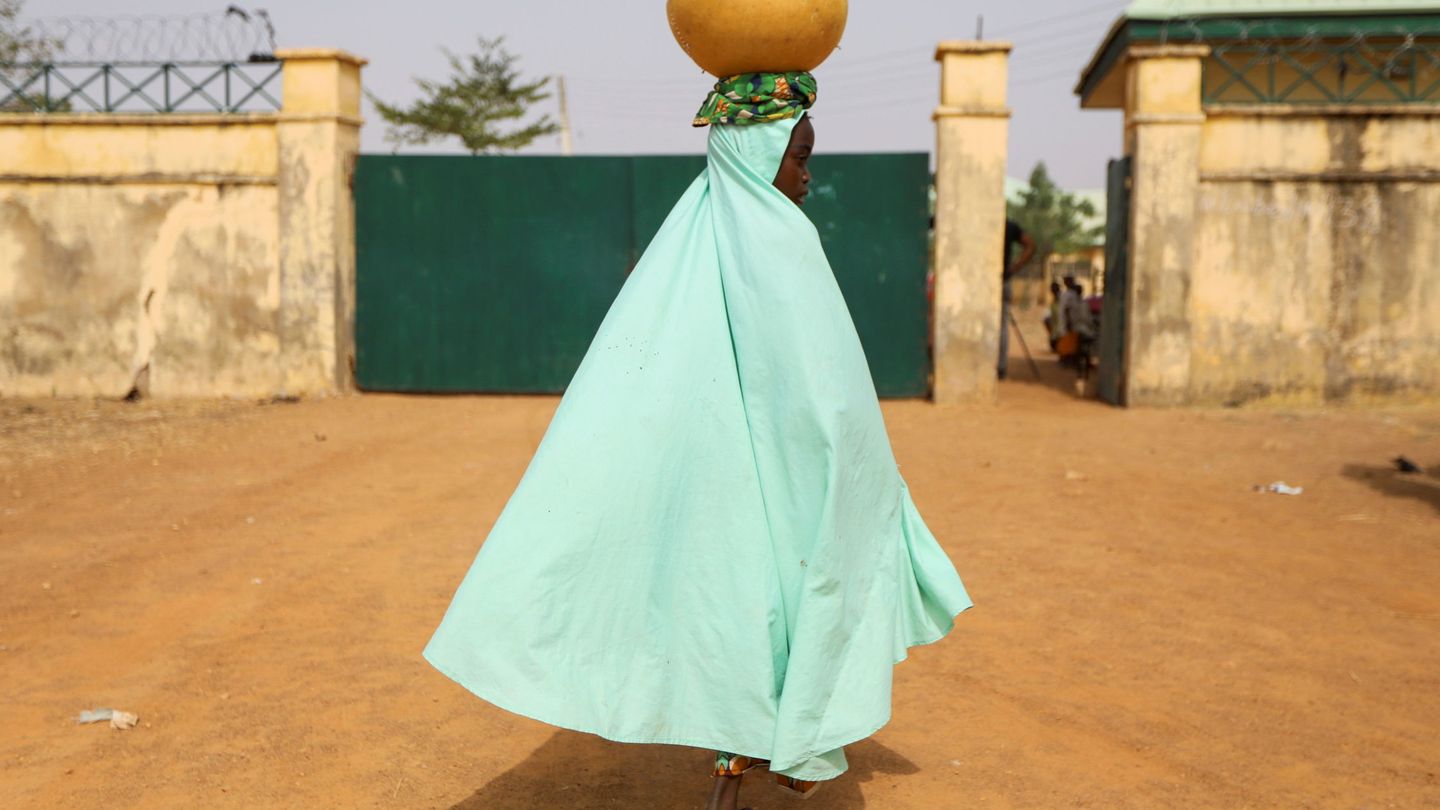 Una mujer camina hacia la puerta de la escuela donde 300 niñas fueron secuestradas en Zamfara, Nigeria. (Reuters) 
