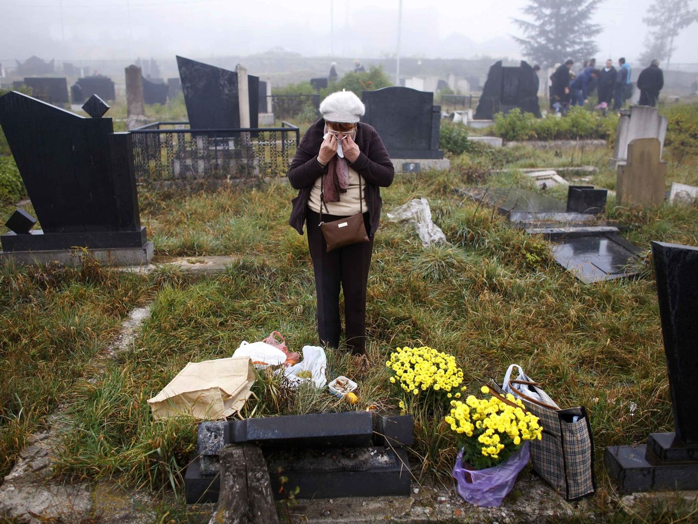 Una mujer serbokosovas llora ante una tumba profanada en Mitrovica (Reuters).