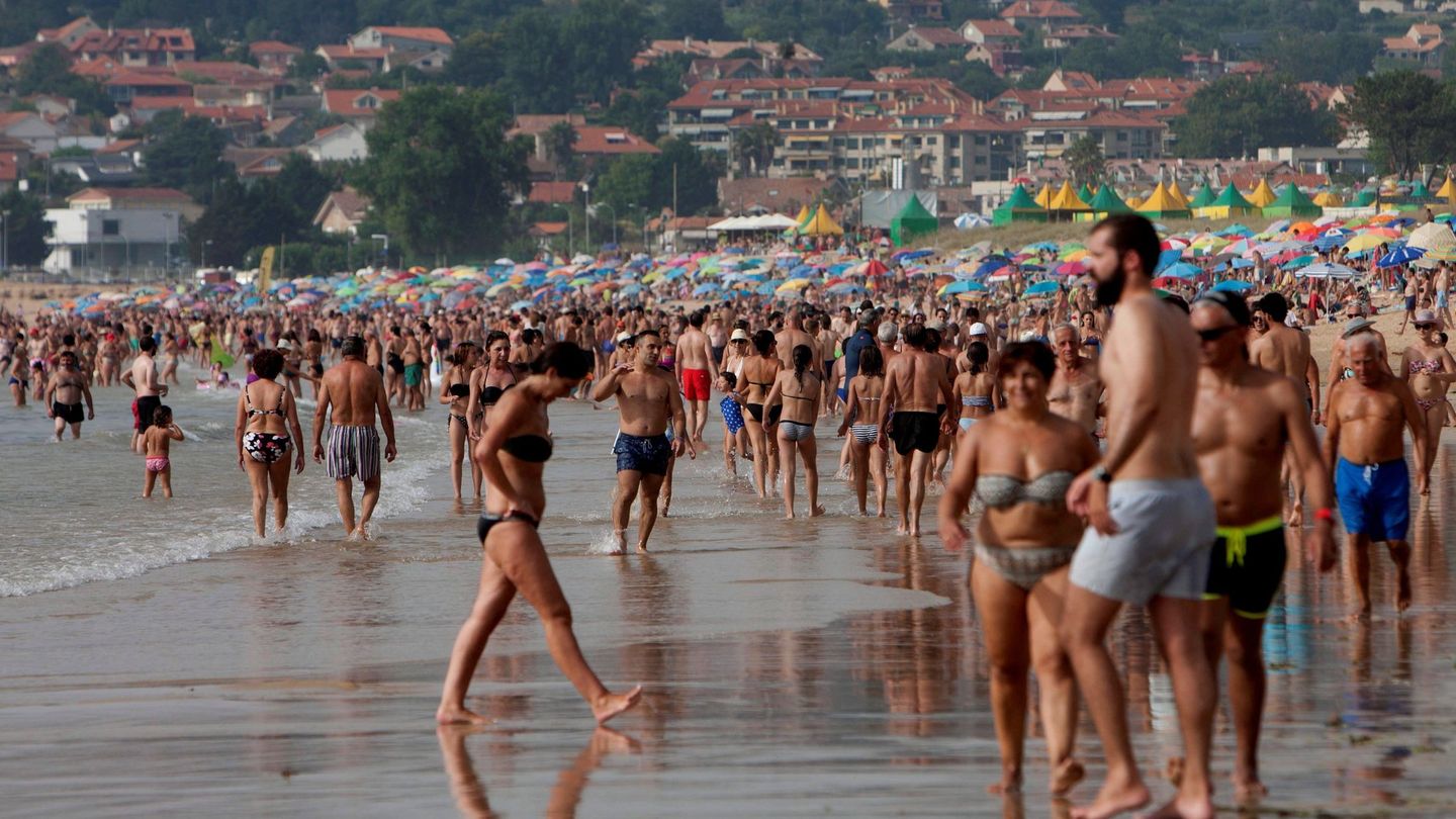 Turistas y vecinos se refrescan en la Playa América en Nigrán (Pontevedra), en 2018. (EFE)