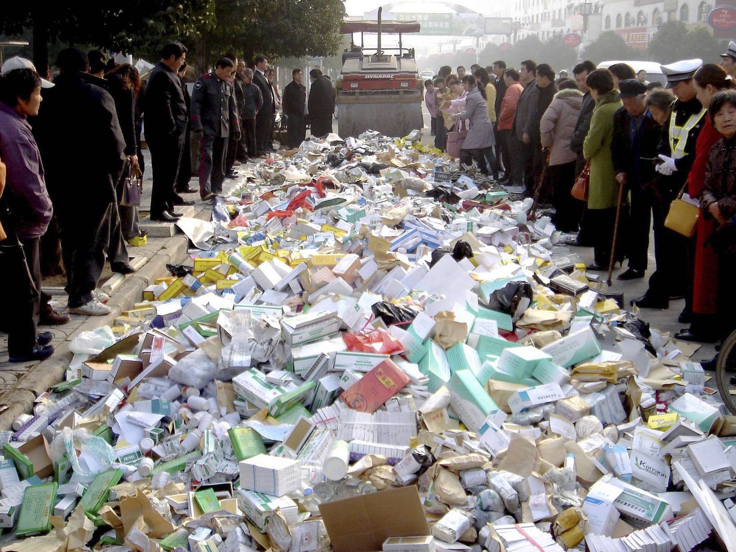 Vecinos de Suqian observan la destrucción de medicamentos falsificados con una apisonadora, en diciembre de 2006. (Reuters)