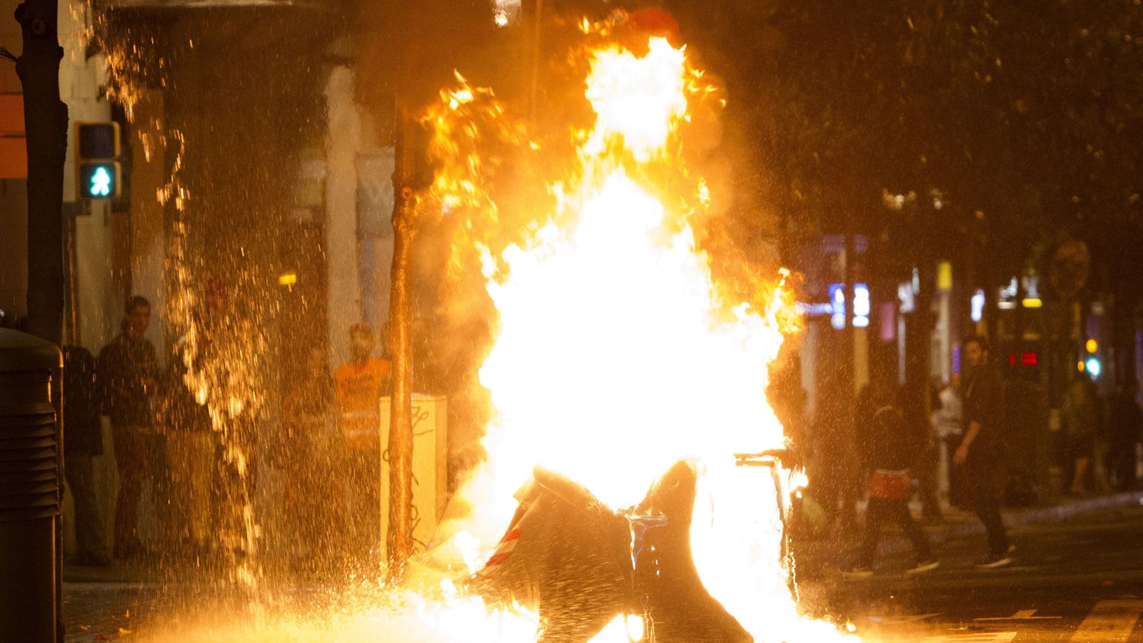 Foto: Varios contenedores han sido incendiados en la calle Gran de Gràcia de Barcelona, tras el tercer día de protestas por el desalojo del 'banco expropiado'. (EFE)