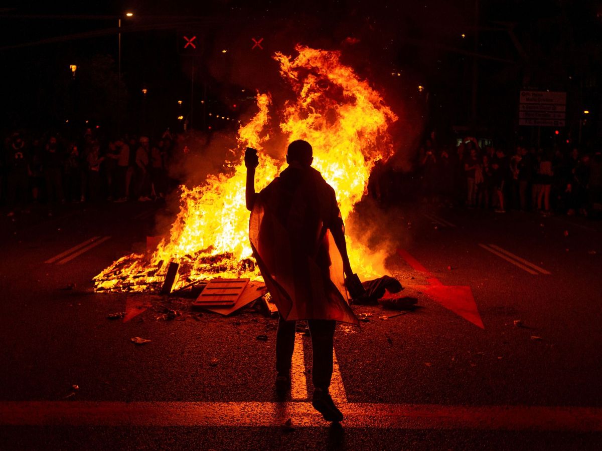 Foto: Un manifestante aviva la hoguera en la manifestación contra el Rey. (EFE)