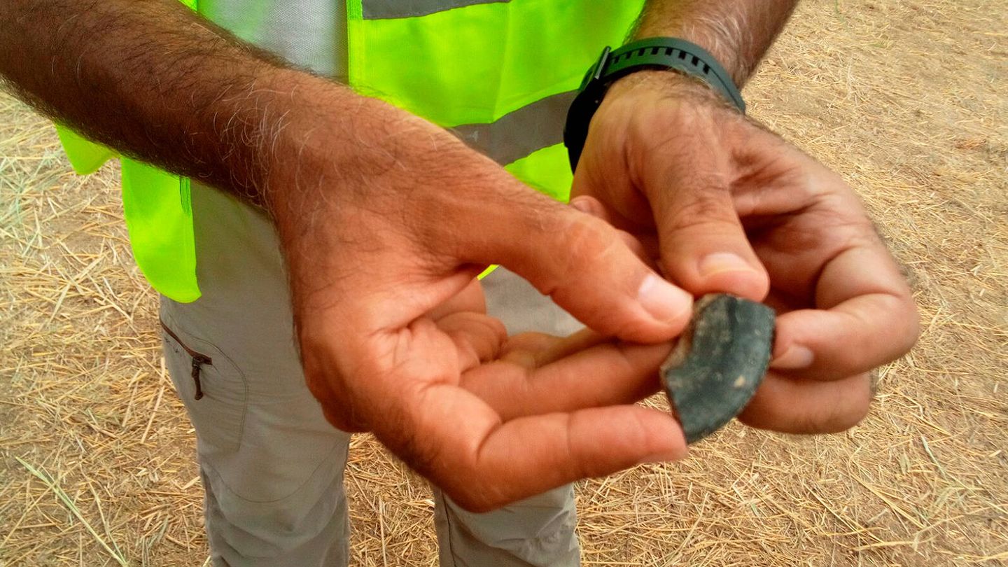 José Suárez, coordinador de la excavación, muestra el trozo de cerámica etrusca hallado este miércoles.