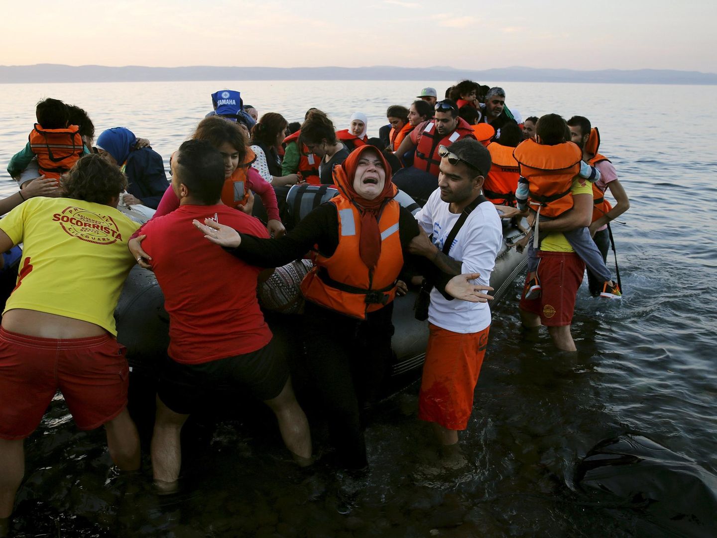 Una refugiada siria al llegar con su familia en una lancha neumática a la isla griega de Lesbos desde las costas de Turquía. (Reuters)