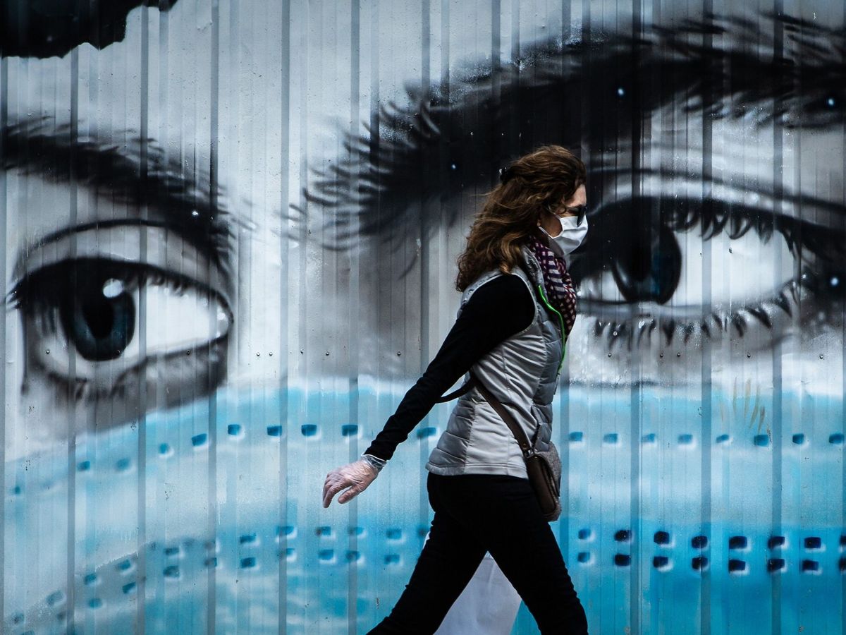Foto: Una mujer camina ante un grafiti en Barcelona. (EFE)