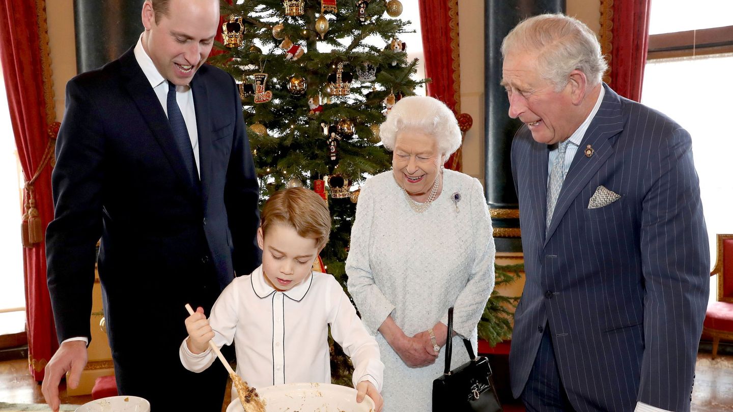 La reina, junto a su hijo Carlos, su nieto Guillermo y su bisnieto George preparando pudin navideño. (Buckingham Palace)