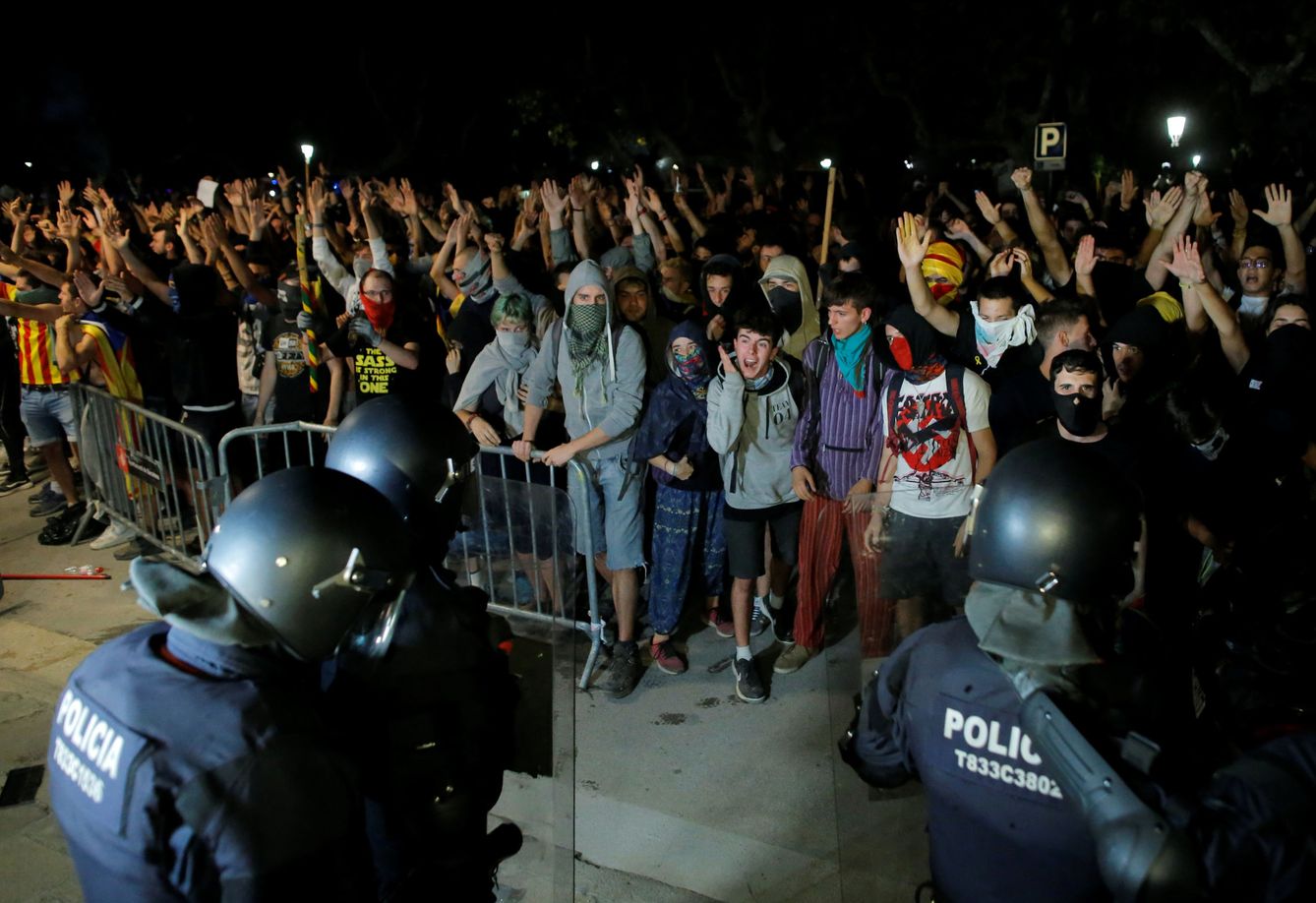 Manifestantes frente a los mossos en el Parlament de Catalunya. (Reuters)
