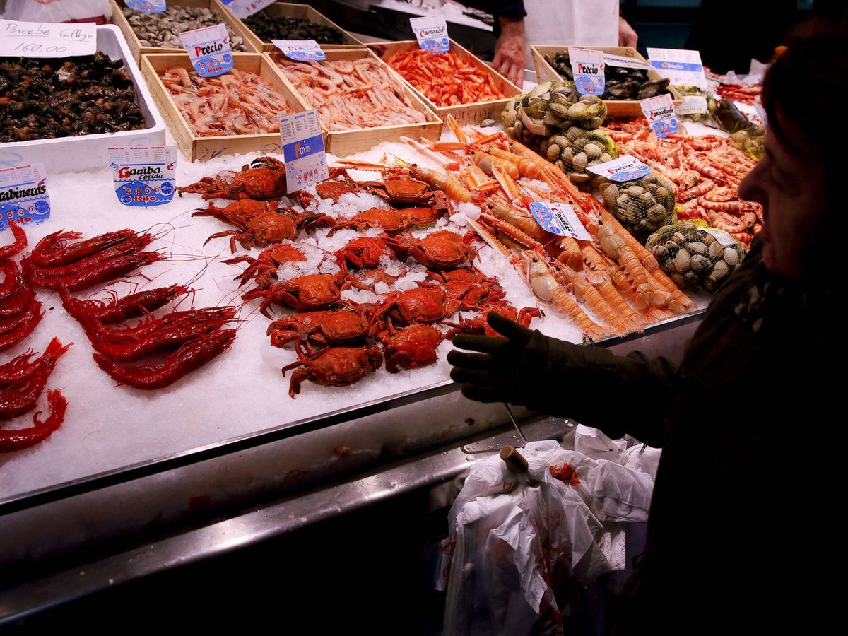 Foto: Una mujer observa los mariscos en un puesto del Mercado de Maravillas, en Madrid