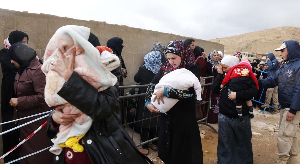 Refugiadas sirias con sus hijos cruzan la frontera de Líbano en Arsal el pasado noviembre (Reuters). 