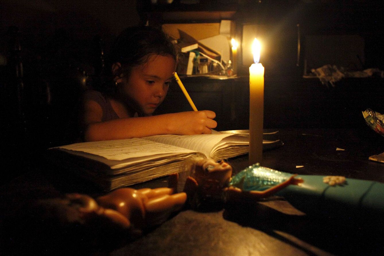 Una niña hace los deberes a la luz de las velas durante un apagón en San Cristobal, estado de Tachira, el 25 de abril de 2016 (Reuters)