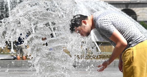Foto: Un hombre se refresca en los chorros de agua de una fuente. (EFE)