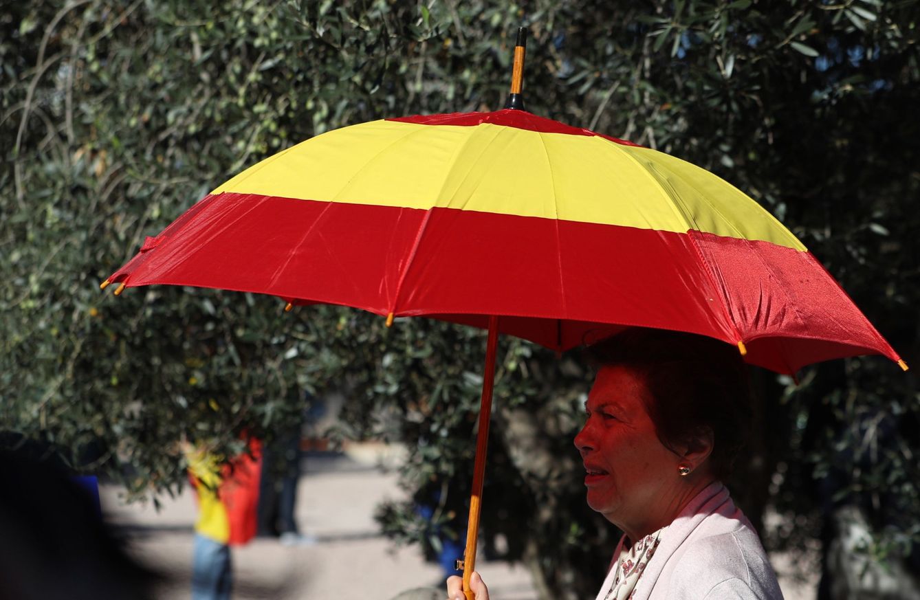 Una mujer, con un paraguas de la bandera de España. (EFE)