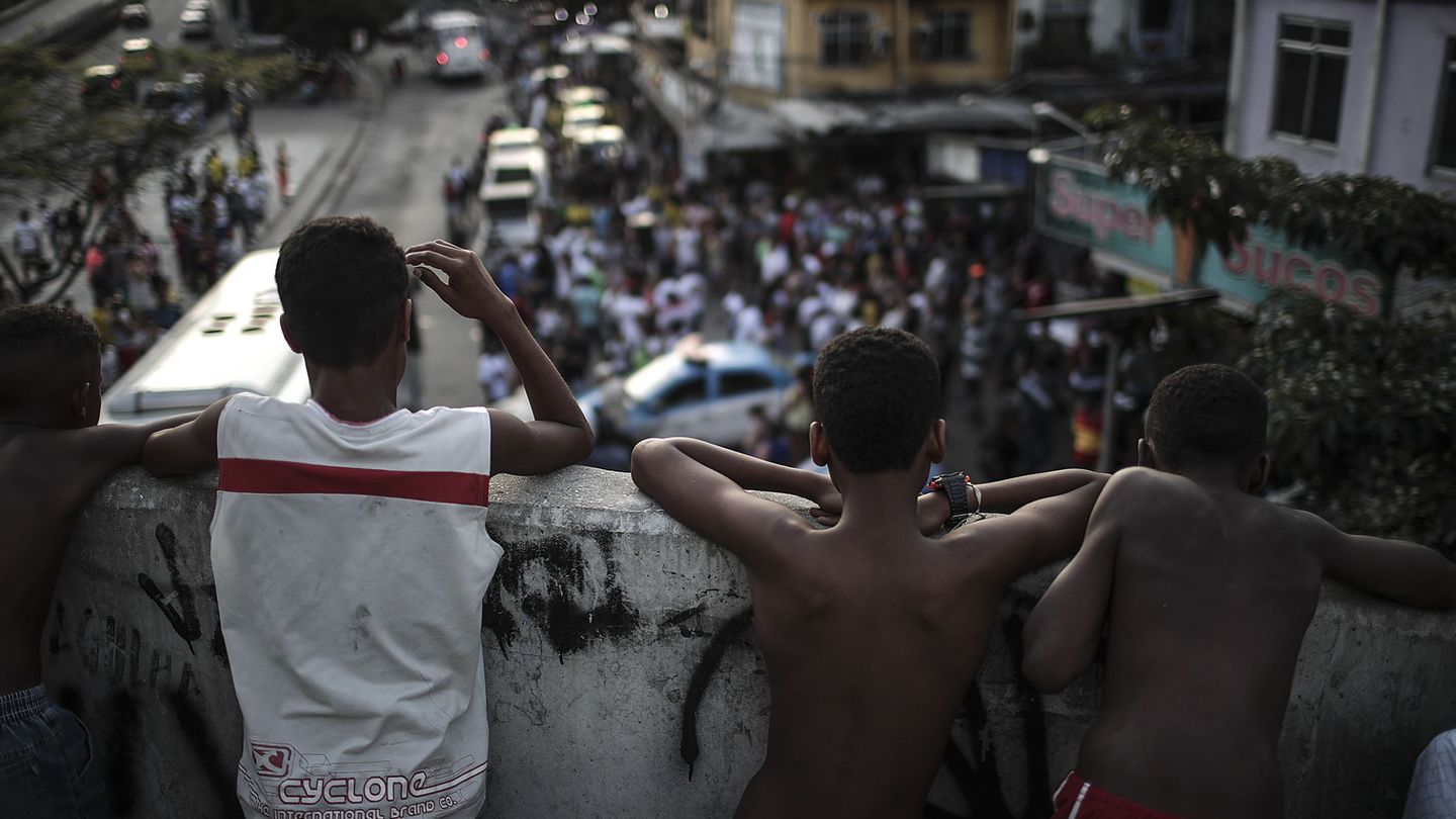 Un grupo de jóvenes de Rocinha observan una marcha que pide paz, el 19 de octubre de 2017. (EFE)