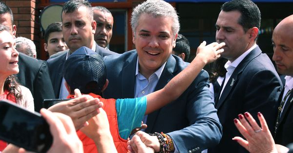 Foto: El candidato presidencial Iván Duque (d) saluda a sus simpatizantes a su llega a su puesto de votación hoy, domingo 17 de junio de 2018, en Bogotá. (EFE)