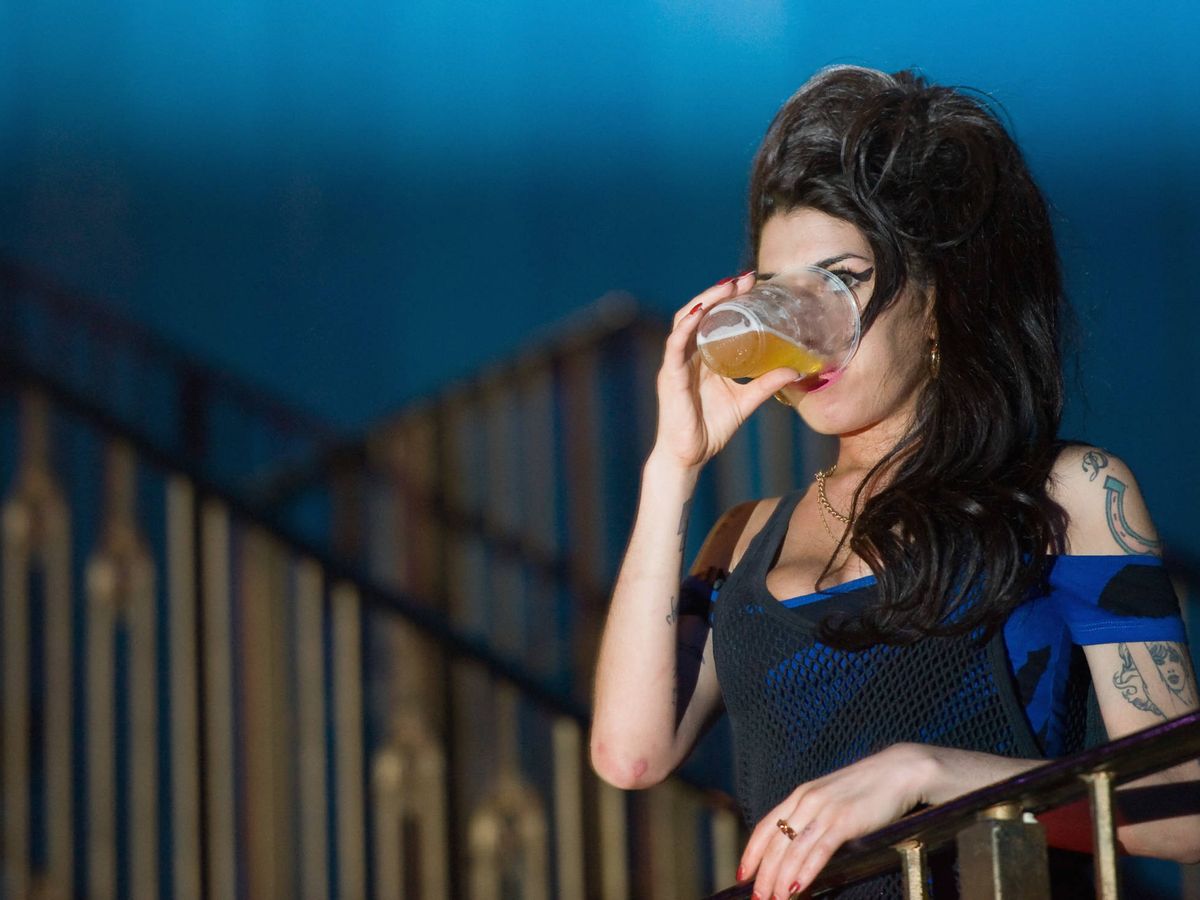 Foto:  Amy Winehouse, bebiendo una cerveza durante un concierto. (Getty)