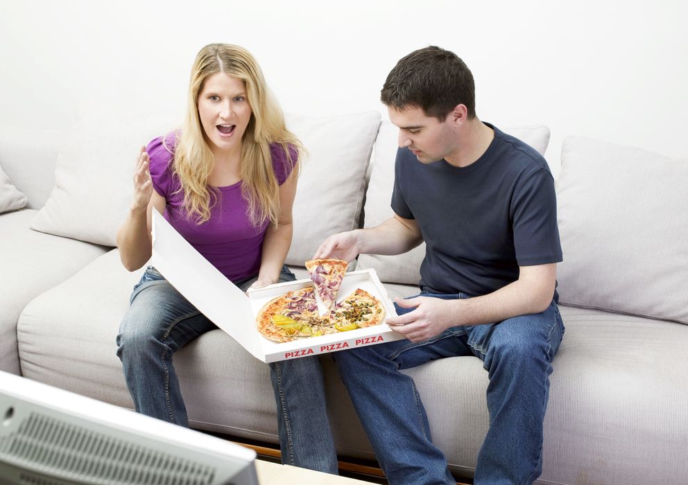 Foto: Comer frente al televisor, distraídos, es la forma más fácil de dejarnos llevar y comer más de la cuenta. (Corbis)