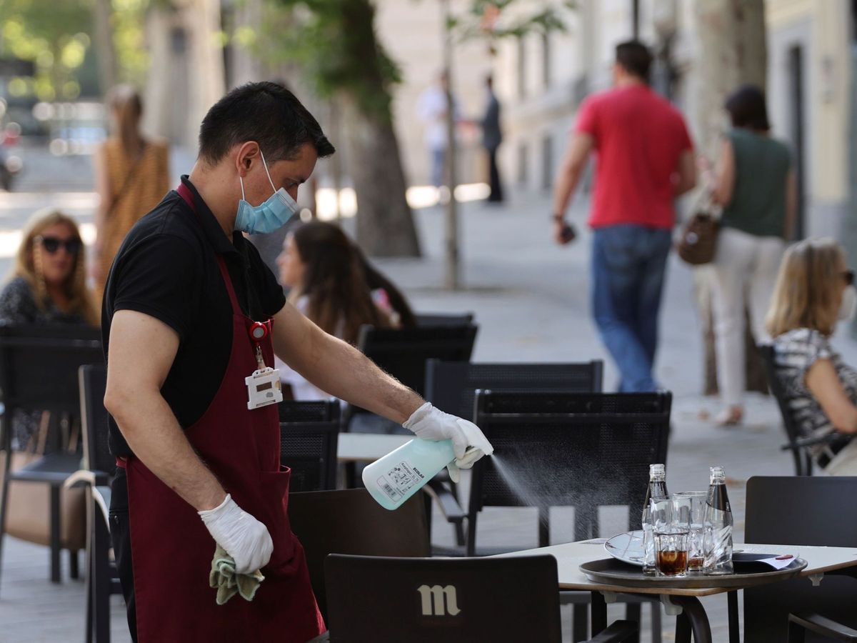 Foto: Un camarero desinfecta una mesa en Madrid. (EFE)