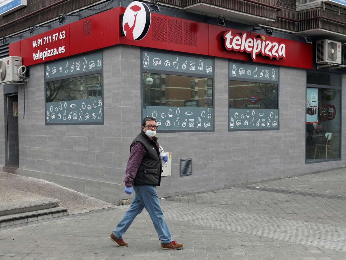 Foto: Un hombre camina frente a un local de Telepizza en Madrid. (EFE)