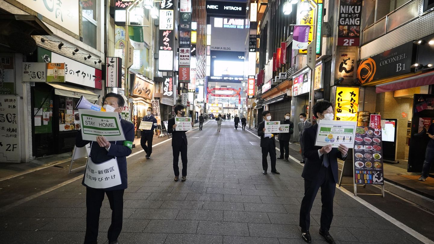 Japoneses pidiendo a los ciudadanos quedarse en casa en Tokio. (EFE)