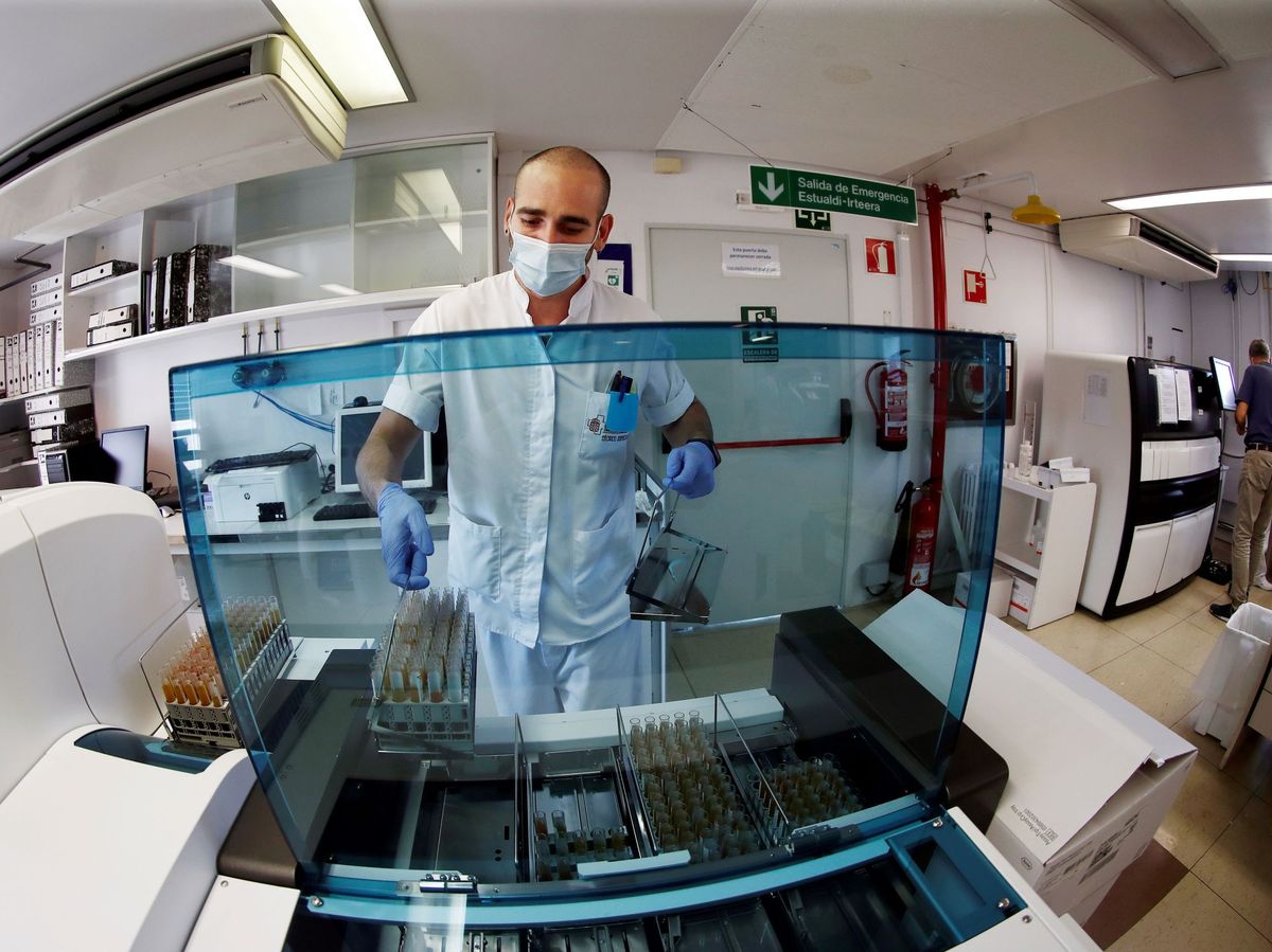 Foto: Técnicos de laboratorio del Complejo Hospitalario de Navarra procesan muestras serológicas para su posterior análisis. (EFE)