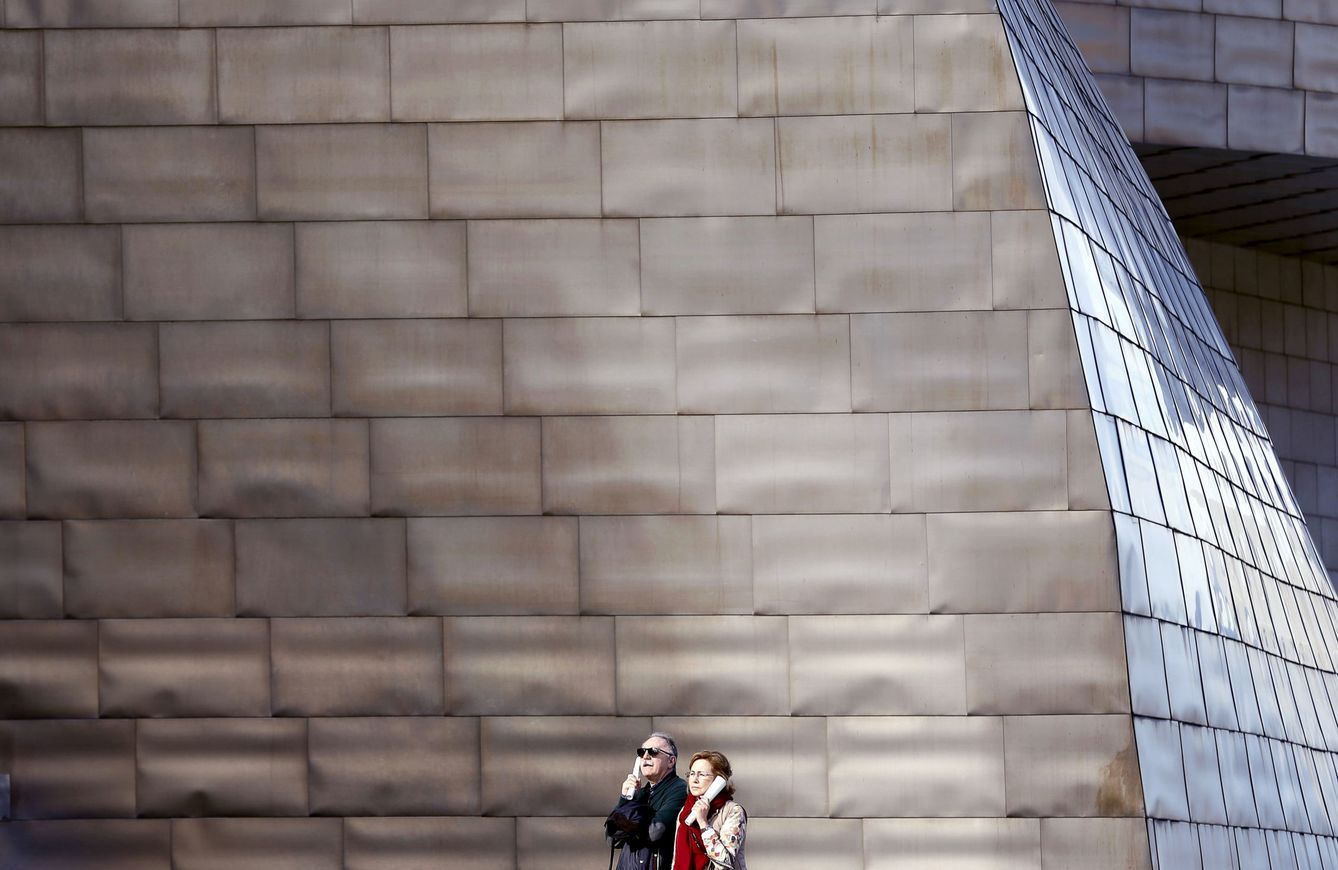 Dos turistas escuchan audioguías en el Museo Guggenheim de Bilbao. (EFE)