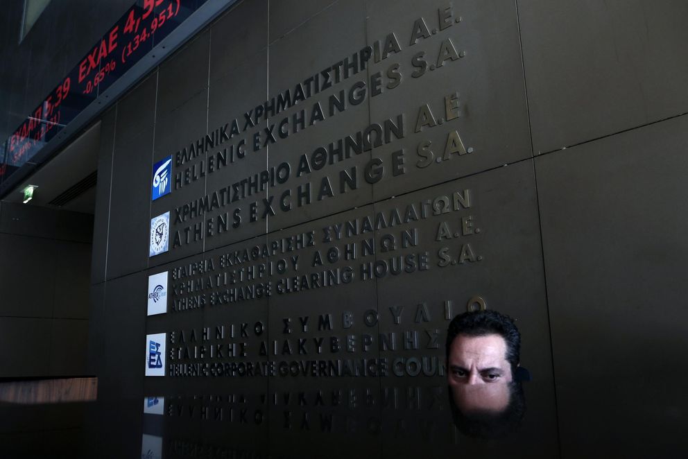Un empleado en la puerta de la bolsa de Atenas (Reuters).