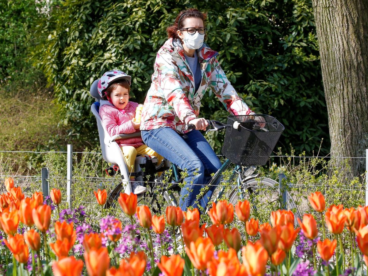 Foto: Una mujer pasea en bicicleta con su hija por Bruselas. EFE