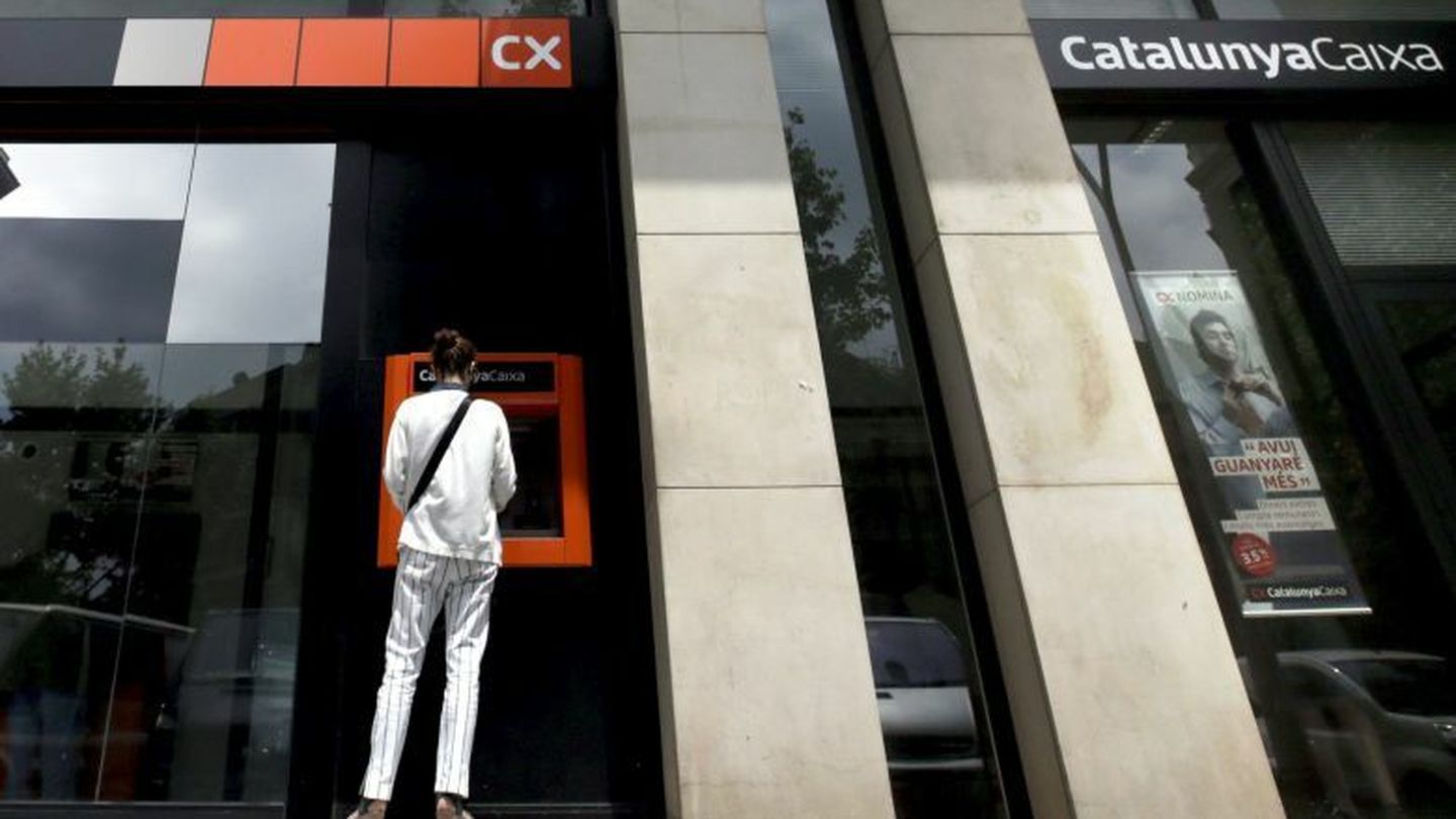 Una mujer utilizando un cajero automático de Catalunya Caixa en Barcelona. (EFE)