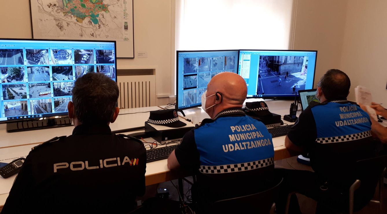 Efectivos policiales miran la cámaras en la sala de control del Ayuntamiento de Pamplona. (J.M.A.)