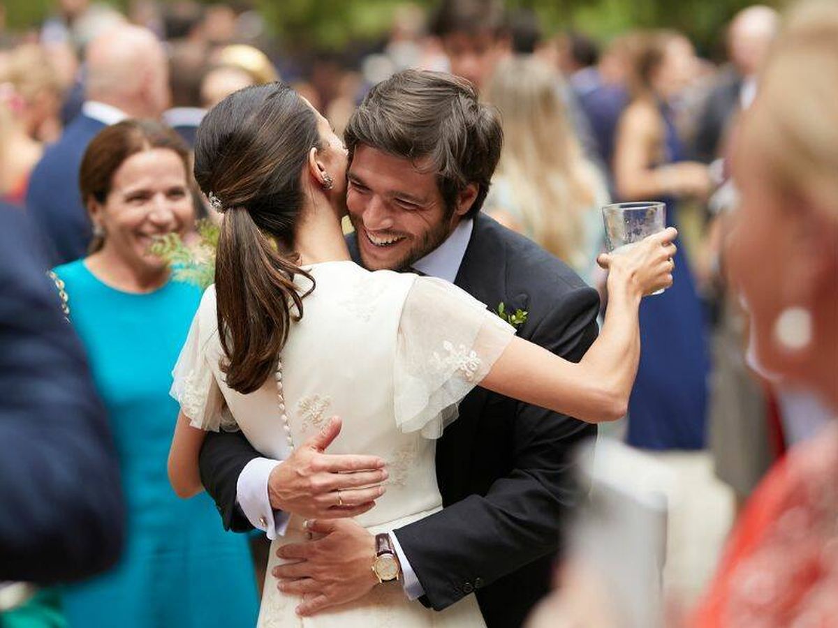 Foto: Laura Corsini, abrazada por su marido tras enseñarle el segundo vestido de novia. (Dos más en la mesa)