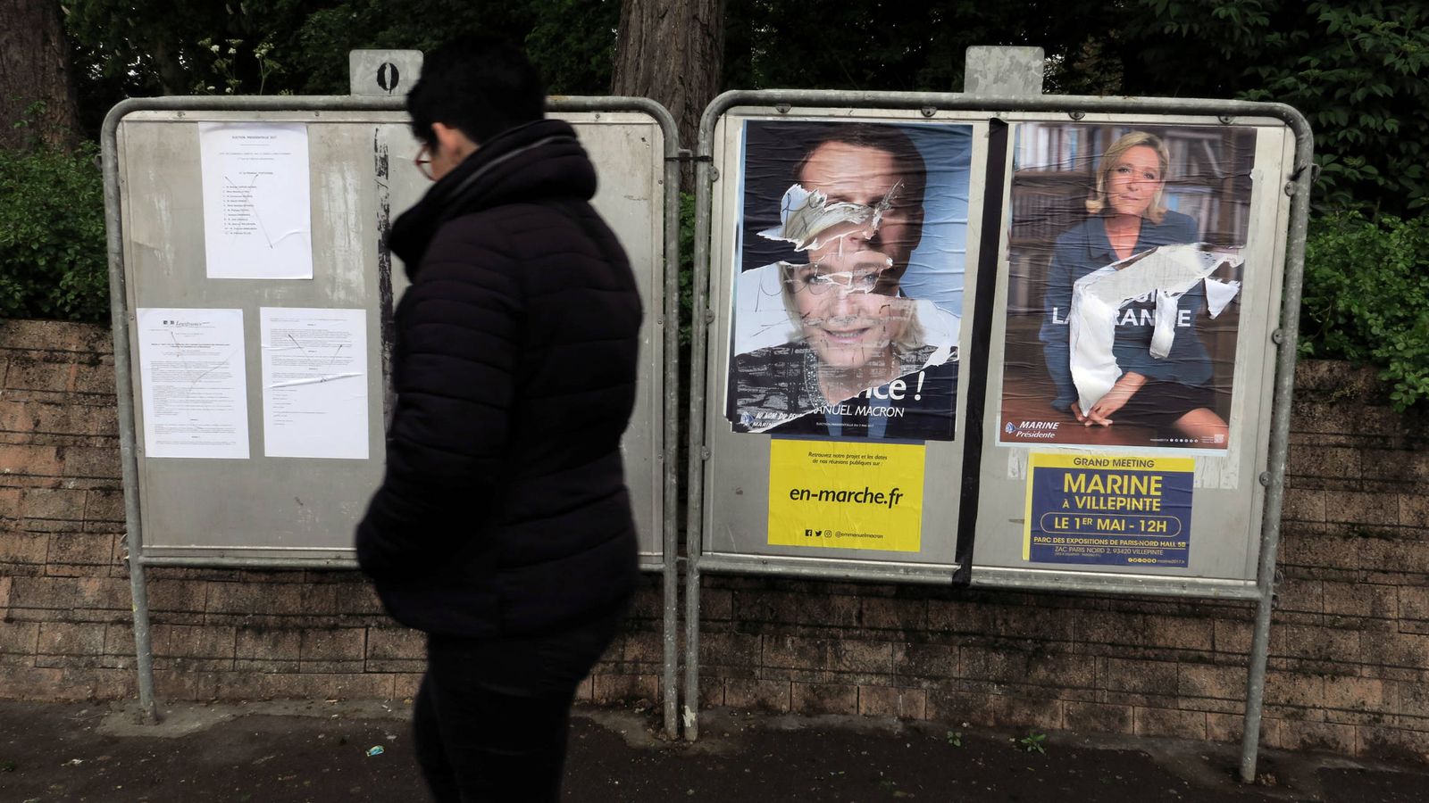 Foto: Una mujer pasa ante carteles electorales de Macron y Le Pen en Cambrai, Francia. (Reuters) 